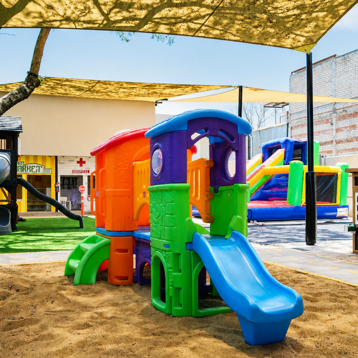 Arenero con resbaladilla e inflable en el área de juegos de Diversitopía.