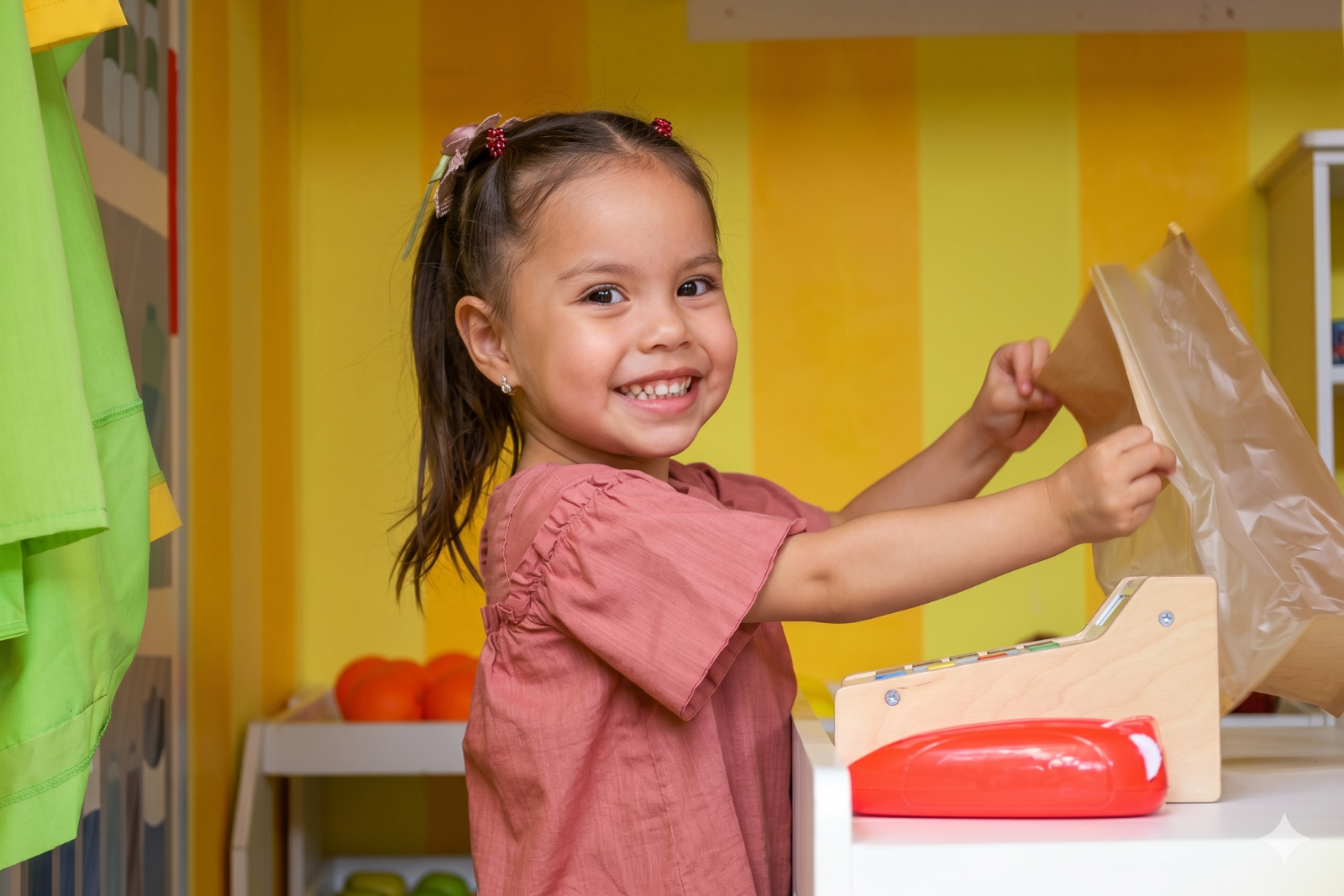 Niña sonriendo en el supermercado infantil de Diversitopía, mini ciudad para fiestas infantiles en Oaxaca.
